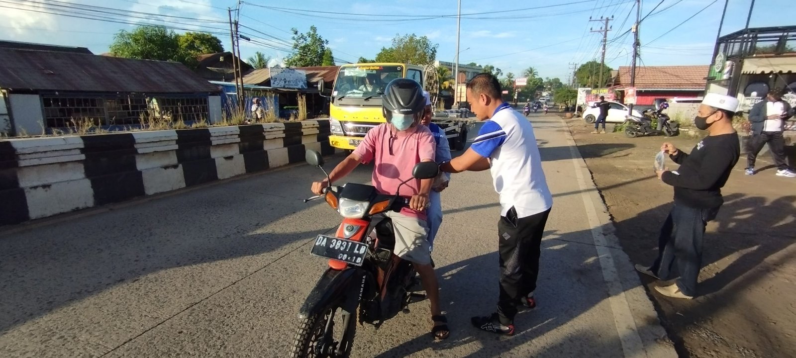 Personil Polsek Satui saat membagikan nasi bungkus kepada pengguna jalan.